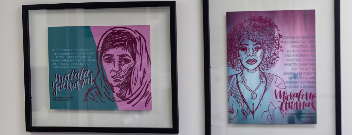 Colorful framed art depicting drawings of women.